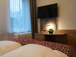 a hotel room with a bed and a flat screen tv at Hotel Stadion Stadt in Hamburg