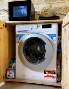 eine Waschmaschine auf einem Regal mit einer Mikrowelle in der Unterkunft Casa Vacanze A un Passo dal Volo in Bari