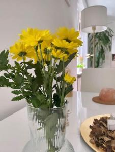 eine Vase voller gelber Blumen auf einem Tisch in der Unterkunft Bilocale ristrutturato, Lingotto in Turin