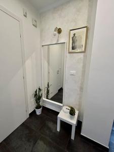 einen Flur mit einem Spiegel und einem Tisch mit Pflanzen in der Unterkunft Bilocale ristrutturato, Lingotto in Turin