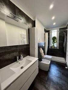 ein Badezimmer mit einem weißen Waschbecken und einem WC in der Unterkunft Bilocale ristrutturato, Lingotto in Turin