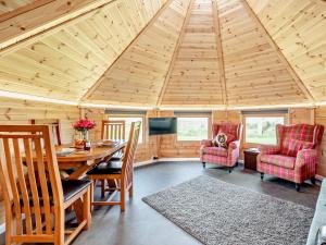 1 Bed in Biggar 91249 في Libberton: غرفة طعام ذات سقف خشبي وطاولة وكراسي