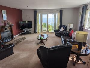 a living room with leather furniture and a television at Pier View in Spittal