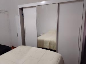 ein Schlafzimmer mit einem Spiegel neben einem Bett in der Unterkunft Copacabana -Cidade maravilha in Rio de Janeiro