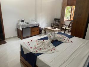 a bedroom with a bed with two swans on it at Sandaru villa in Induruwa
