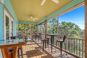 eine abgeschirmte Veranda mit Tischen und Stühlen auf einem Balkon in der Unterkunft Pirate Daze in Fort Morgan