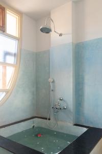 a bathroom with a bath tub with a shower at Rajan House in Jaipur