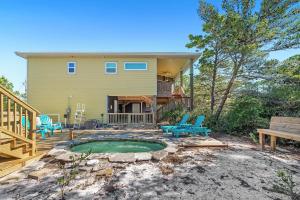 ein Haus mit einem Pool und Stühlen im Hof in der Unterkunft Pirate Daze in Fort Morgan