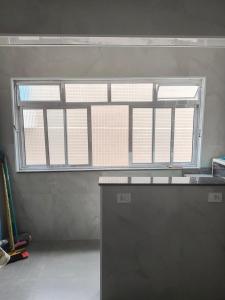 uma grande janela num quarto com um balcão em Astúrias no Guarujá