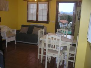 sala de estar con mesa, sillas y sofá en Apartamentos Los Ánades, en Isla