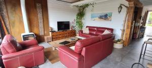 una sala de estar con 2 sillas rojas y una mesa. en Lodge Terre de Glisse, en San Juan de Luz