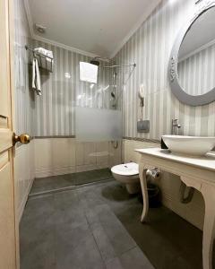 a bathroom with a toilet and a sink and a mirror at Muyan Suites in Istanbul