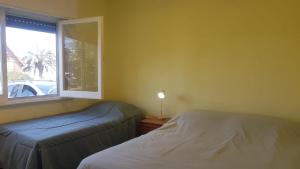 a bedroom with two beds next to a window at Rubedo - Punta Fria in Piriápolis