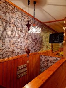 a stone wall in a bar with a chandelier at Cabaña León in Puerto Natales
