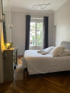 Schlafzimmer mit einem großen weißen Bett und einem Fenster in der Unterkunft Belges in Lyon