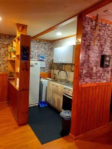 a kitchen with a white refrigerator and a stove at Cabaña León in Puerto Natales