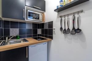 cocina con fregadero y utensilios en la pared en Lille Centre - Nice & functional studio en Lille
