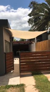 a house with a gate and a fence with a canopy at Rubedo - Punta Fria in Piriápolis
