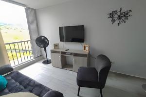 Una televisión o centro de entretenimiento en GURUS FR | Elegante Apartamento en parque acuático Dosquebradas