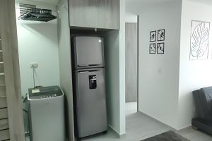 cocina con nevera en una habitación en GURUS FR | Elegante Apartamento en parque acuático Dosquebradas, en Dosquebradas