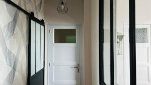 a hallway with a white door and a window at l'albatros "le pont" in Cayeux-sur-Mer