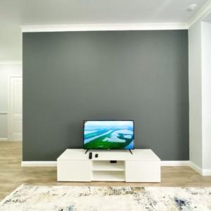 una sala de estar con TV en un armario blanco en Highvill Ishim 412 en Astaná