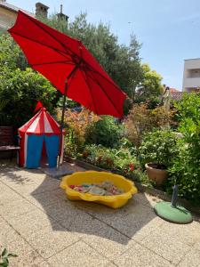 a red umbrella sitting next to a yellow tub at Family Apartments Vesna- 100 m Beach -Center Crikvenica in Crikvenica