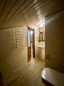 baño con aseo, lavabo y puerta en Resort Stariy Prud, en Filippovichi