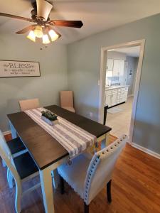uma sala de jantar com uma mesa e cadeiras e uma ventoinha de tecto em Andrea Abode em Lexington