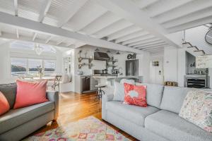 a living room with two couches and a kitchen at Cozy Cottage on the Penobscot — Panoramic Luxury! 