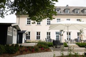 einen Regenschirm und einen Stuhl vor einem Gebäude in der Unterkunft Hotel Haus Delecke in Möhnesee