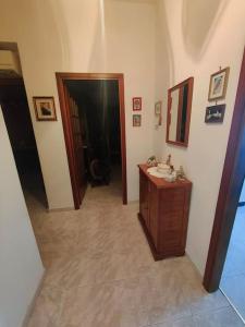 a hallway with a bathroom with a sink and a mirror at Casa zia Maria in Priolo Gargallo