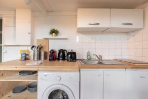 a kitchen with a sink and a washing machine at Studio fonctionnel à 3 min du métro in Lille