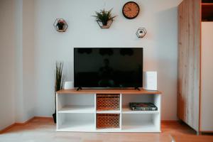 a living room with a television on a white entertainment center at Schönbrunn Gardens Vienna Apartment in Vienna