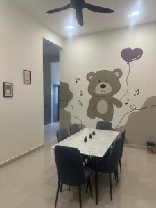 班台的住宿－Pantai Remis Bear Homestay，用餐室配有桌子,墙上挂着泰迪熊