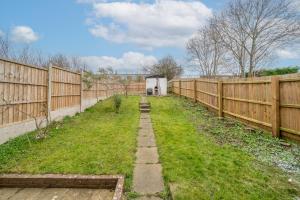 een tuin met een houten hek en gras bij Skyvillion-STEVENAGE Amazing 3Bed House, Garden, Free Off Street Parking for 2 Cars, WiFi in Stevenage