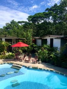 uma casa com piscina e guarda-sol vermelho em Rema K A Y A K Lodge em Tena