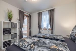Schlafzimmer mit einem Bett und einem Fenster in der Unterkunft "Home to Enjoy" Premium Appartement in Sonnenalpe Nassfeld