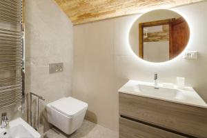 a bathroom with a sink and a toilet and a mirror at La Piccola Corte in Spello