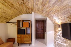 una camera con un muro in pietra e una porta in legno di La Piccola Corte a Spello