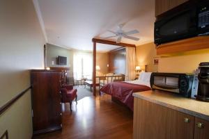 a hotel room with a bed and a kitchen at Relais St-Denis in Saint-Sauveur-des-Monts