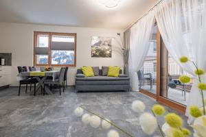 ein Wohnzimmer mit einem Sofa und einem Tisch in der Unterkunft "Home to Enjoy" Premium Appartement in Sonnenalpe Nassfeld