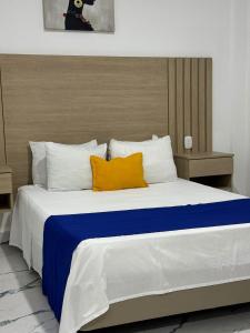 1 dormitorio con 1 cama grande y 2 almohadas amarillas en Hotel ITACO, en Cartagena de Indias