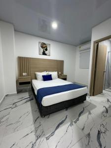- une chambre avec un lit king-size et des draps bleus dans l'établissement Hotel ITACO, à Carthagène des Indes