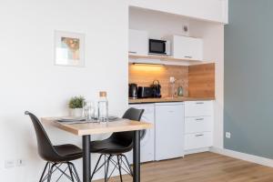 eine kleine Küche mit einem Tisch und Stühlen in der Unterkunft Close to the city centre - Appartment confortable in Lille