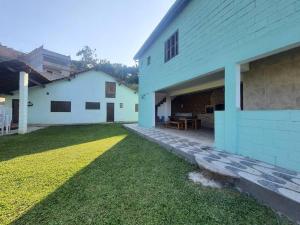 une arrière-cour d'une maison blanche avec une terrasse dans l'établissement Chácara ( Dona Juju) super confortável em Igarata/SP!, à Igaratá