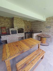 Cette chambre comprend une grande table en bois et une cheminée. dans l'établissement Chácara ( Dona Juju) super confortável em Igarata/SP!, à Igaratá