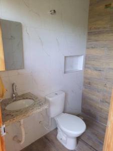 uma casa de banho com um WC branco e um lavatório. em Chácara ( Dona Juju) super confortável em Igarata/SP! em Igaratá