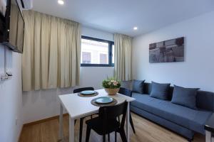 ein Wohnzimmer mit einem blauen Sofa und einem Tisch in der Unterkunft Live in Aveiro in Aveiro