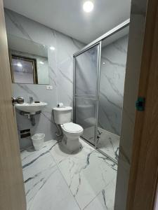 a white bathroom with a toilet and a sink at Hotel ITACO in Cartagena de Indias